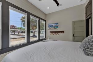 a bedroom with a large bed and large windows at Historic Gem near Schlitterbahn in New Braunfels