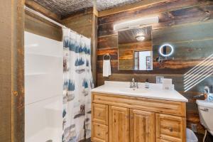a bathroom with a sink and a toilet and a mirror at Grizzly Bear Creek- Mt Rushmore Views- Hot tub in Keystone +49 photos