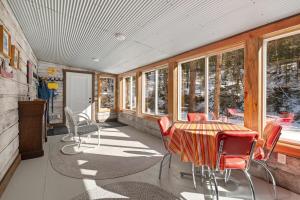 a screened in porch with a table and chairs at Grizzly Bear Creek- Mt Rushmore Views- Hot tub in Keystone