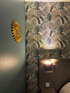 a mirror on a wall next to a toilet in a bathroom at Hôtel Le Valois, Cognac Centre in Cognac