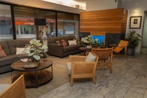 a living room with couches and tables and a tv at Hotel Don Luis Puerto Montt in Puerto Montt
