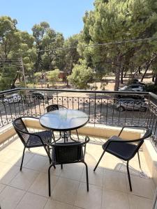 a table and chairs on a balcony with a view of a park at Loxandra Studios in Metamorfosi