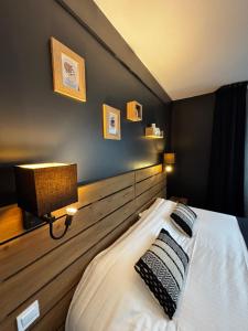 a bedroom with a bed with a wooden headboard at Hôtel Le Valois, Cognac Centre in Cognac