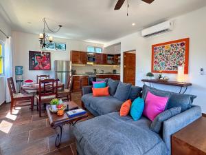 a living room with a blue couch and a table at Casa Catalina - Tropical Escape in Puerto Morelos