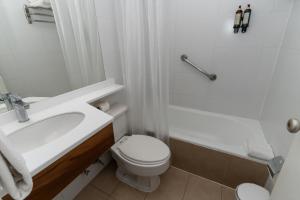 a white bathroom with a toilet and a sink at Hotel Don Luis Puerto Montt in Puerto Montt +40 photos