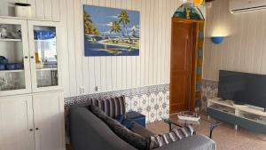 a living room with a couch and a tv at Shell's Apartment in Praia do Carvoeiro