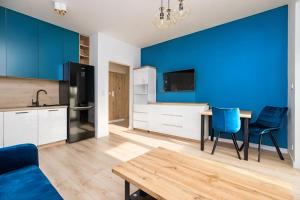a living room with a table and a blue wall at JetSet Airport Apartment in Warsaw