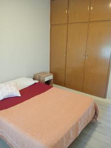 a bedroom with a bed and wooden cabinets at Mansilla playa in Mar del Plata