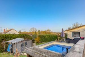 a swimming pool on the deck of a house at Maison 7 personnes avec piscine proche de Disneyland Paris in Villiers-sur-Morin