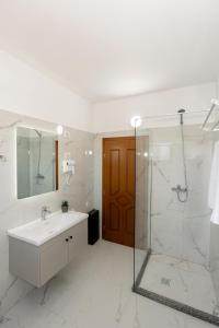 a white bathroom with a sink and a shower at Guesthouse 3 Diamonds in Omarë