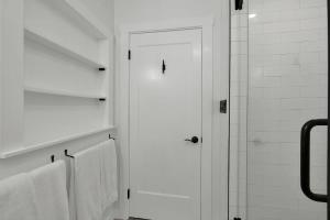 a bathroom with white towels and a glass shower at Rojo-Charming unit walking distance to Main St! in Fredericksburg