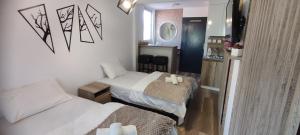 a small room with two beds and a mirror at Pearl's apartments Old town Ohrid in Ohrid