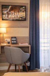 a room with a desk with a tv and a chair at Les Treize Assiettes - Baie du Mont-Saint-Michel in Le Val-Saint-Père