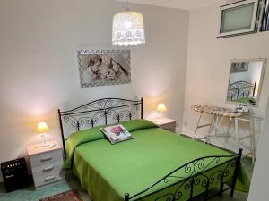 a bedroom with a green bed and two night stands at Villetta Capilungo by Paf in tour in Capilungo