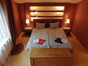 a bedroom with a bed with two red shoes on it at Villa EverGreen near the city center with private garden, hot tub, garage parking, patio in Vilnius