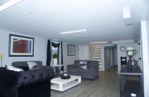 a living room with two couches and a staircase at Basemant private room 21 in Guttenberg