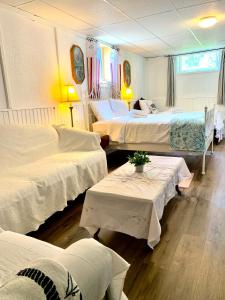 a hotel room with three beds and two tables at 8 Clarence Ln in Cavendish