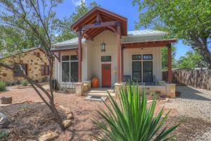 a small house with a red door in a yard at Chic Comfort Just Steps from Main Street! in Fredericksburg