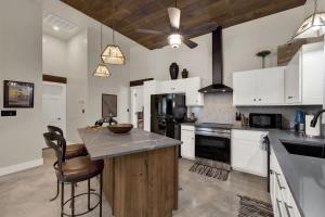 a large kitchen with white cabinets and a counter top at Chic Comfort Just Steps from Main Street! in Fredericksburg +15 photos
