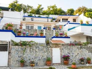 a building with potted plants on a stone wall at Hotel Sociedad y Maristas in Tecolutla