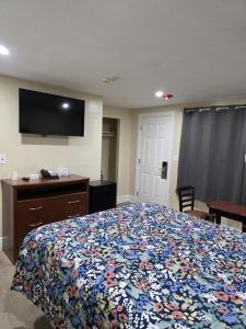a bedroom with a bed and a tv on the wall at James Motel in Saugus