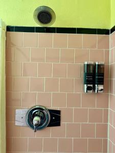 a tiled bathroom with a blow dryer on a wall at James Motel in Saugus +2 photos