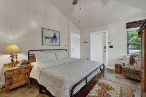 a bedroom with a bed and a table and a chair at Rojo-Charming unit walking distance to Main St! in Fredericksburg