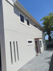a white building with windows on the side of it at De Guest Suites in Eversdal