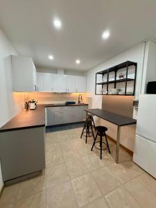 a kitchen with white cabinets and a table and chairs at Residencial Princesa do Ave in Vila do Conde