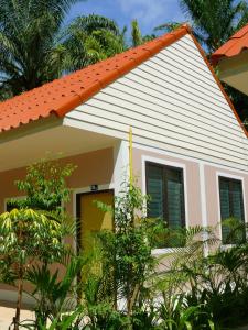 una pequeña casa con techo naranja en Suan Bang Bon Guest House, en Plai Phraya