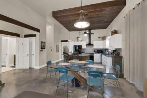 a kitchen with a table and blue chairs in it at Chic Comfort Just Steps from Main Street! in Fredericksburg