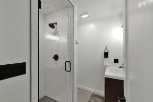 a bathroom with a glass shower and a sink at Chic Comfort Just Steps from Main Street! in Fredericksburg