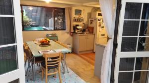 a kitchen and dining room with a table and chairs at Raglan West Retro Beach Vibe Accommodation in Raglan +17 photos