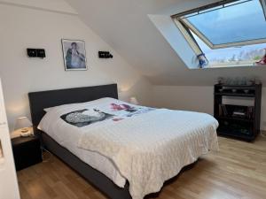 a bedroom with a bed with a large window at Soizic' house in Trébeurden