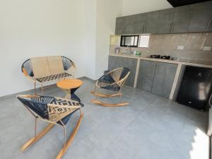 a room with three chairs and a table in a kitchen at Valle de las Bendiciones, Lago Calima in Calima