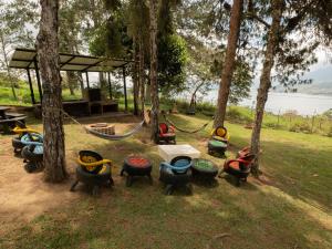 a group of chairs and a hammock in a park at Valle de las Bendiciones, Lago Calima in Calima +11 photos