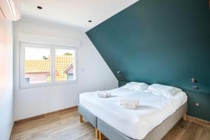 a bedroom with a large bed with a blue wall at Gite Spa L'Atelier Emile - Spa Privatif - 5 min COLMAR in Sainte-Croix-en-Plaine