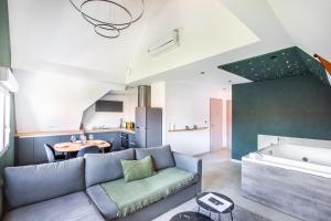 a living room with a couch and a kitchen at Gite Spa L'Atelier Emile - Spa Privatif - 5 min COLMAR in Sainte-Croix-en-Plaine