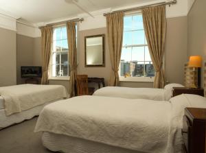a bedroom with three beds and a window at Harveys Guest House in Dublin +39 photos