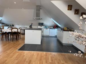 a kitchen and dining room with white cabinets and a table at Soizic' house in Trébeurden