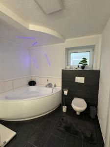 a white bathroom with a tub and a toilet at Elfis Paradise in Wiesbaden +13 photos