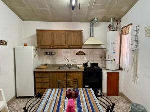 a kitchen with a table and a refrigerator at La Pantera in San Antonio de Arredondo