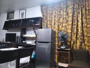 a kitchen with a refrigerator and a table with chairs at Jenny's transient house in Baguio