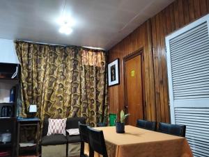 a dining room with a table and chairs and a curtain at Jenny's transient house in Baguio