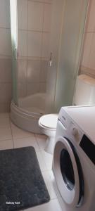 a bathroom with a toilet and a washing machine at Apartman Centar LUX in Jagodina +45 photos