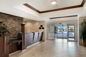 an office lobby with a reception desk and a brick wall at Canalta Wainwright in Wainwright +22 photos