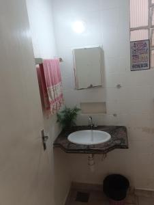 a bathroom with a sink and a mirror at Hotel quarto 01 in Montes Claros