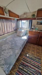 a small bedroom with a bed in an rv at Raglan West Retro Beach Vibe Accommodation in Raglan