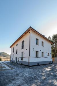 a large white building with a tile roof at Appartament Lago di Braies in San Sigismondo