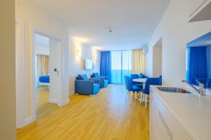 a living room with blue chairs and a kitchen at best VIP HOTEL panorama suites IN batumi R in Batumi